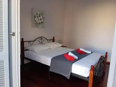 two beds in a bedroom with red and white towels at Quiet private room in a dormitory 5' from metro in Athens
