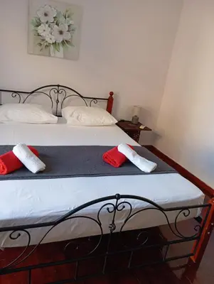a bed with two red and white towels on it at Quiet private room in a dormitory 5' from metro in Athens
