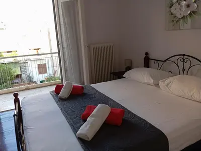 two beds in a bedroom with red and white towels at Quiet private room in a dormitory 5' from metro in Athens