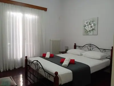 a bedroom with two beds with red and white pillows at Quiet private room in a dormitory 5' from metro in Athens