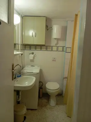 a small bathroom with a toilet and a sink at Quiet private room in a dormitory 5' from metro in Athens