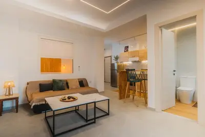 a bedroom with a bed and a table and a kitchen at Calmio Athens 4 in Athens