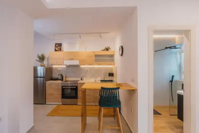 a kitchen with a wooden table and a counter at Calmio Athens 4 in Athens