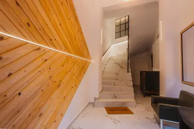 a staircase in a house with a wooden wall at Calmio Athens 4 in Athens