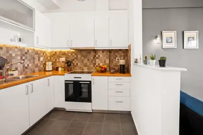 a white kitchen with white cabinets and a sink at Luxury 2BR Penthouse Marina & Sea Views in Piraeus