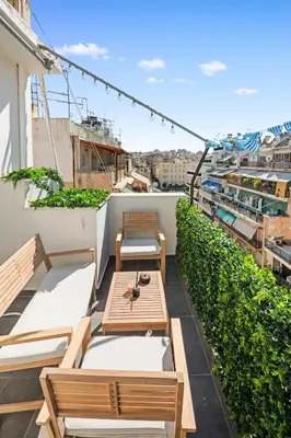 a balcony with wooden tables and benches on a building at Luxury 2BR Penthouse Marina & Sea Views in Piraeus