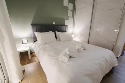 a bedroom with a white bed with towels on it at Luxury 2BR Penthouse Marina & Sea Views in Piraeus