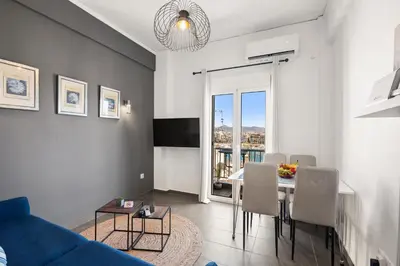a living room with a table and a blue couch at Luxury 2BR Penthouse Marina & Sea Views in Piraeus