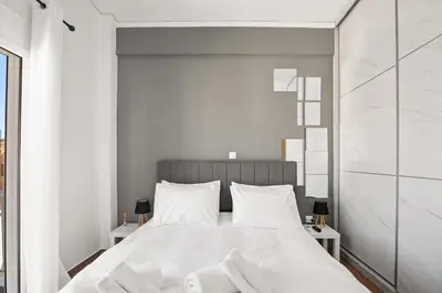 a bedroom with a large white bed with white pillows at Luxury 2BR Penthouse Marina & Sea Views in Piraeus