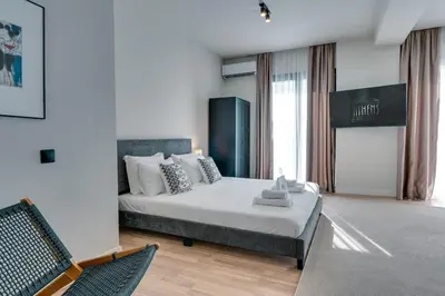 a bedroom with a bed and a chair in it at Skyline Spa Athens 130 A in Athens