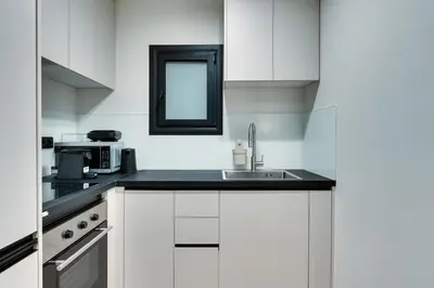 a white kitchen with a sink and a mirror at Skyline Spa Athens 001 in Athens