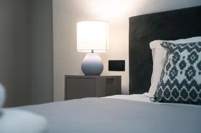 a bedroom with a bed with a lamp on a table at Skyline Spa Athens 001 in Athens
