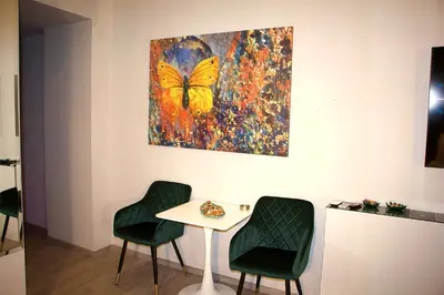 a table and two chairs in a room with a butterfly painting at VIP Suite 107 - Castle De Paris in Athens