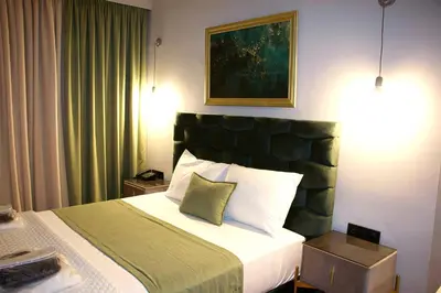 a bedroom with a large bed with a green headboard at VIP Suite 107 - Castle De Paris in Athens