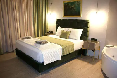 a hotel room with a bed and a bath tub at VIP Suite 107 - Castle De Paris in Athens