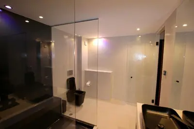 a bathroom with a glass shower and a sink at VIP Suite 108 - Castle De Paris in Athens