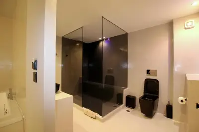 a bathroom with a toilet with a glass wall at VIP Suite 108 - Castle De Paris in Athens