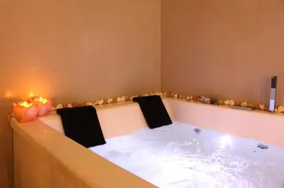 a bath tub with two chairs in it with candles at VIP Suite 108 - Castle De Paris in Athens