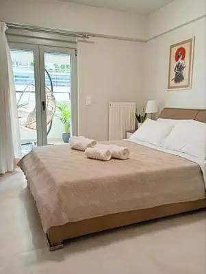 a bedroom with a large bed with towels on it at EazyRent Apartments Athens Comfort-Work Stay-Free Parking in Athens