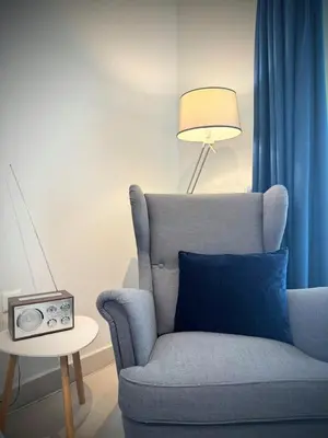a living room with a blue chair and a table with a lamp at EazyRent Apartments Athens Comfort-Work Stay-Free Parking in Athens