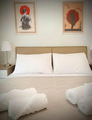 a bed with two white towels on top of it at EazyRent Apartments Athens Comfort-Work Stay-Free Parking in Athens