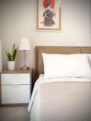 a bedroom with a bed and a table with a lamp at EazyRent Apartments Athens Comfort-Work Stay-Free Parking in Athens