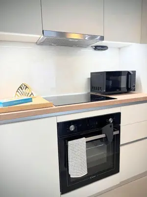 a kitchen with a microwave and a black oven at EazyRent Apartments Athens Comfort-Work Stay-Free Parking in Athens