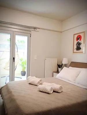 a bedroom with a bed with towels on it at EazyRent Apartments Athens Comfort-Work Stay-Free Parking in Athens