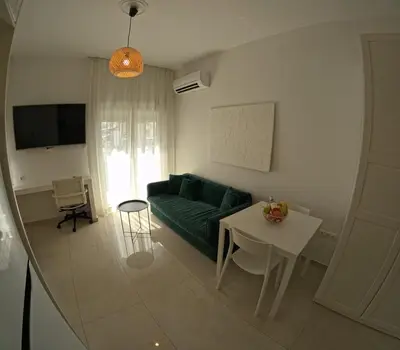 a living room with a green couch and a table at Little Big Athens in Athens