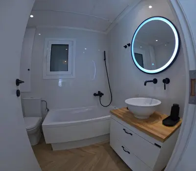 a bathroom with a tub and a sink and a mirror at Little Big Athens in Athens