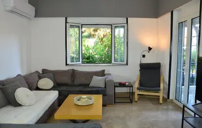 a living room with a couch and a chair at Spacious house by the sea in Athens