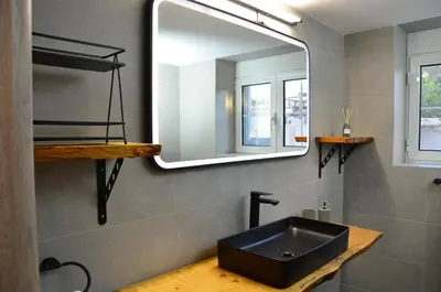 a bathroom with a black sink and a mirror at Spacious house by the sea in Athens