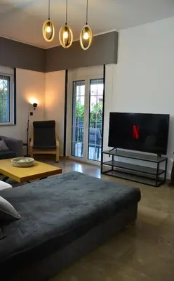a living room with a large tv and a couch at Spacious house by the sea in Athens