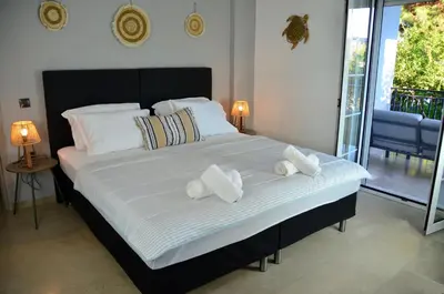 a large bed with two pillows on it in a bedroom at Spacious house by the sea in Athens