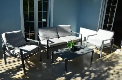 three chairs and a couch and a table on a porch at Spacious house by the sea in Athens