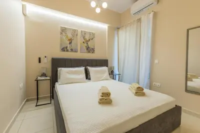 a bedroom with a large bed with towels on it at Saronic retreat Varkiza in Vari
