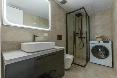 a bathroom with a sink and a washing machine at Saronic retreat Varkiza in Vari
