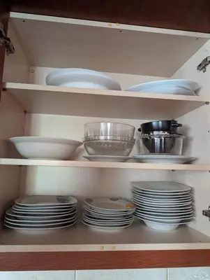 a cabinet filled with plates and bowls and dishes at Family apartment mountain and sea in Athens