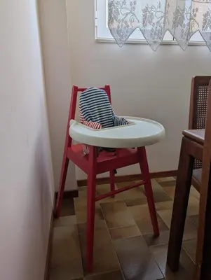 a red chair with a white table on top of it at Family apartment mountain and sea in Athens