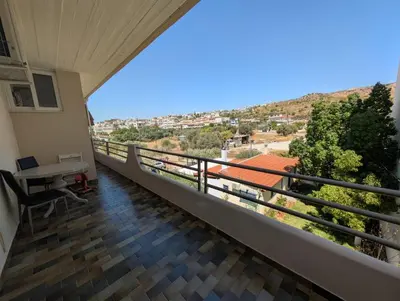 a balcony of a house with a desk and a view at Family apartment mountain and sea in Athens