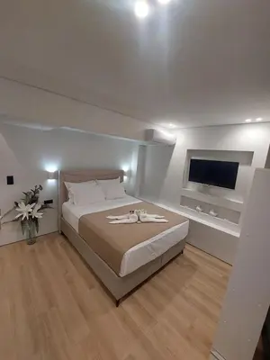 a bedroom with a large bed and a flat screen tv at LD Homes 1 in Athens