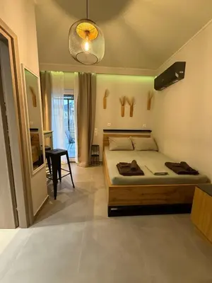 a bedroom with a bed and a table and a lamp at FiftyFiveLoft in Ano Glyfada in Athens