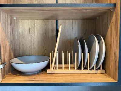 a wooden cabinet with plates and a bowl in it at FiftyFiveLoft in Ano Glyfada in Athens