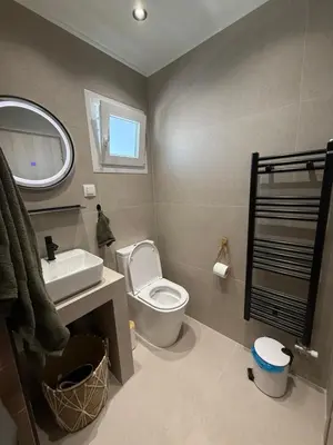 a bathroom with a toilet and a sink and a mirror at FiftyFiveLoft in Ano Glyfada in Athens