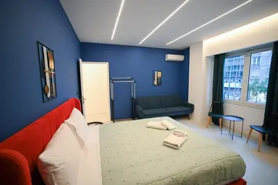 a blue room with a bed and a couch at Apollon Residence Patision by Zeussuites in Athens
