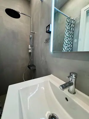 a white sink in a bathroom with a mirror at Apollon Residence Patision by Zeussuites in Athens
