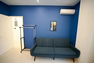 a couch in a room with a blue wall at Apollon Residence Patision by Zeussuites in Athens