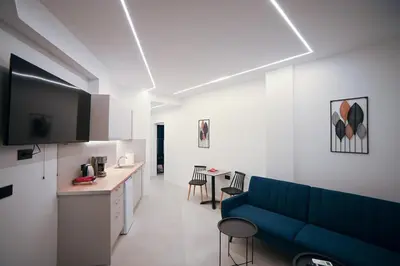 a living room with a blue couch and a table at Apollon Residence Patision by Zeussuites in Athens