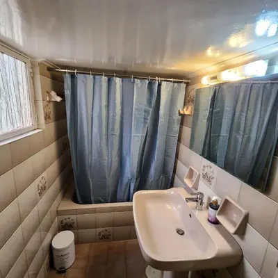 a bathroom with a sink and a blue shower curtain at Athens Acropolis in Athens