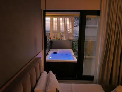 a hotel room with a hot tub on a balcony at JKB Panoramic Suites in Athens